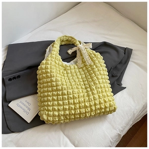Close-up of yellow popcorn fabric bag with a delicate white lace bow detail