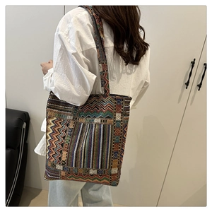 Detail of colorful ethnic woven tote bag with geometric patterns and broad shoulder strap