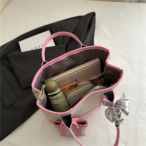 Fashionable beige canvas tote bag with pink trim showing interior storage capacity