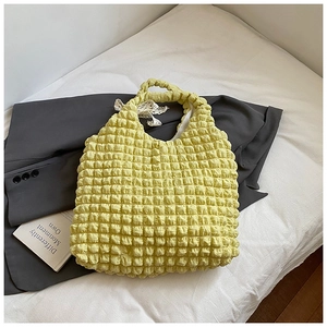 Detailed view of pale yellow popcorn bubble texture fabric on a ruffled tote bag