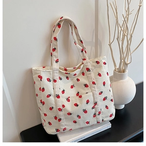 Dettaglio della borsa tote con stampa a fragole in velluto a coste color crema