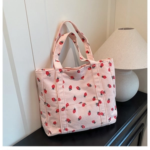 Dettaglio della trama di una borsa tote in velluto rosa con stampa di fragole