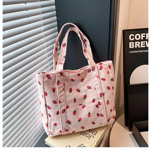 Dettaglio della borsa tote in velluto a coste rosa con stampa di fragole e cuciture ampie