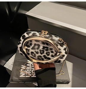 Macro view of leopard print texture and oval gold handle on minimalist crossbody bag