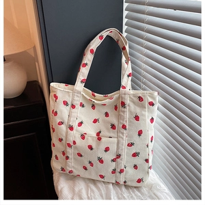 Dettaglio borsa tote in velluto a coste con stampa fragola, tasca e doppi manici