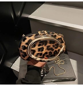 Macro detail of leopard print clutch with glossy finish and gold metal handle