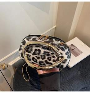 Detailed macro of vintage leopard print handbag with golden oval handle and chain strap