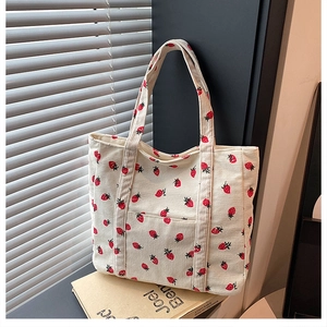 Dettaglio della borsa tote in velluto a coste bianco crema con stampe di fragole