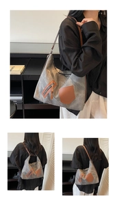 Detail of grey canvas tote bag with brown leather accents and large capacity design