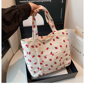 Dettaglio della borsa tote in velluto a coste bianco sporco con stampa di fragole