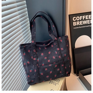 Dettaglio della borsa tote in velluto a coste blu con simpatica stampa di fragole