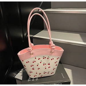 Close-up of pink and white bucket bag featuring sweet cherry prints and tied rope handle