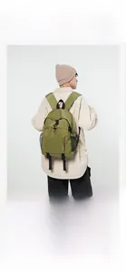 Rear view of a light green large-capacity casual backpack shown on models in a studio setting