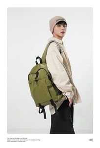 Detail of green nylon backpack with durable mesh side pocket and adjustable black strap