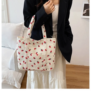 Dettaglio della stampa a fragola sulla borsa tote in velluto con tasca