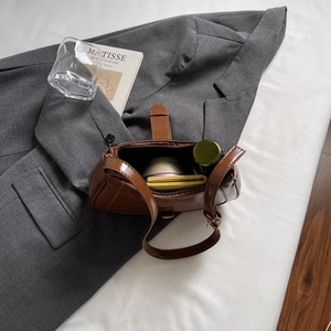 Sac baguette en cuir verni marron avec bandoulière réglable et intérieur spacieux