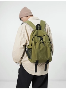 Detailed back view of an olive green ripstop nylon backpack with side mesh pockets