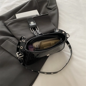 Black crocodile pattern shoulder bag with silver grommet strap showing interior capacity