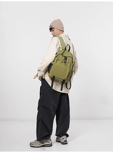 Detail of green nylon backpack side pocket and adjustable buckle on ripstop fabric