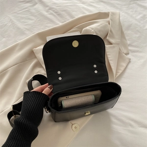 Minimalist black crossbody square bag showing spacious interior with metal magnetic closure