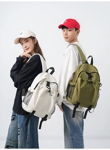 Front view of white and olive green backpacks worn by models for travel and school