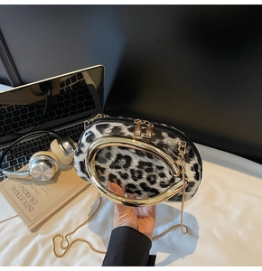 Macro view of leopard print bag with large golden circular metal handle and gold chain