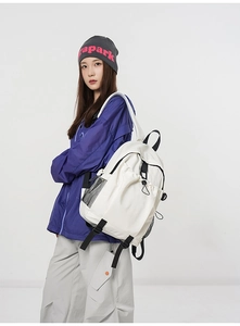 Side view of white minimalist multi-functional backpack with mesh pocket and buckle strap