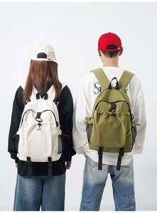 Detailed view of unisex backpacks in green and beige featuring drawstring front pockets