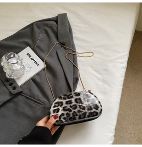 Detail of trendy leopard print shoulder bag with gold chain on a grey blazer suit