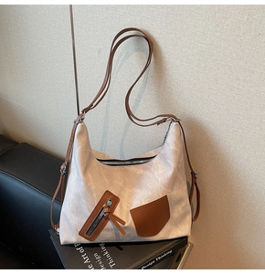 Close-up of marble pattern canvas tote bag with brown leather pockets and adjustable strap