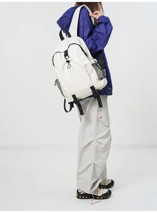Side view of cream white minimalist backpack featuring multi-zipper compartments and mesh pockets