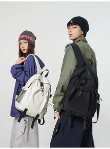 Side view of black and white minimalist backpacks with side mesh pockets on models