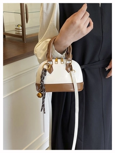 Détail du sac coquillage bicolore marron et blanc avec fermetures éclair dorées