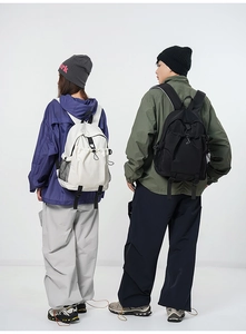 Rear view of models wearing large capacity backpacks in beige and black colors