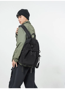 Black durable backpack with drawstring closure and mesh side pocket shown on back
