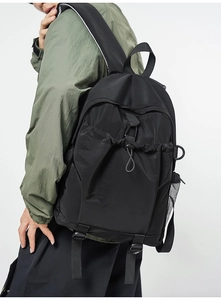 Close-up of black backpack featuring ripstop nylon texture and side mesh pocket detail