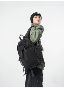 Male model wearing high-capacity black tactical backpack with functional pockets