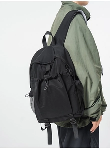 Side view of a black nylon backpack featuring drawstring design and mesh side pockets