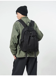 Macro detail of waterproof black nylon backpack showing drawstring and mesh side pocket