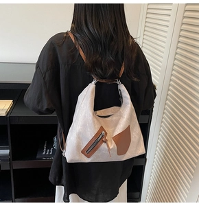 Model view of large contrast-color tote bag showing the stylish backpack carry style
