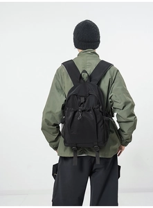Rear view of black nylon backpack with drawstring closure and side mesh pocket detail