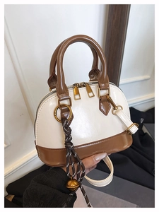 Détail du sac coquillage bicolore avec double fermeture éclair et breloque boule tissée