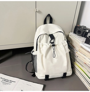 Detail of minimalist cream backpack with drawstring front pocket and mesh side pockets