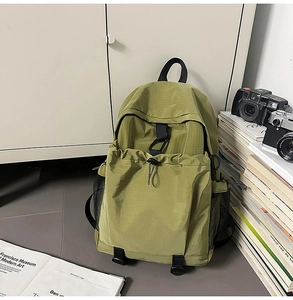 Detailed macro view of green durable nylon fabric and drawstring closure on the backpack