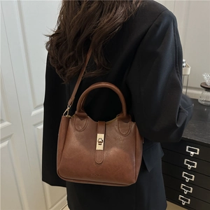 Sac seau en cuir marron foncé avec fermoir doré et poignée pour femme en bandoulière