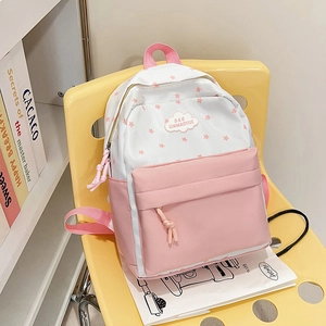 Sac à dos d'école rose et blanc avec motifs d'étoiles et logo nuage sur chaise jaune