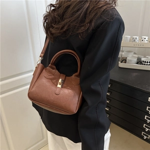 Sac seau vintage en cuir PU marron avec poignée et gaufrage mode porté par un mannequin