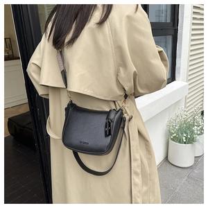 Close-up of black litchi pattern bucket bag featuring dual straps and FASHION logo