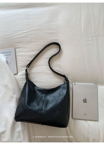Top-down view of black PU leather hobo bag showing large capacity and soft texture