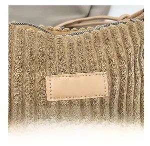 Gros plan détaillé sur le tissu en velours côtelé marron avec empiècement en cuir du sac